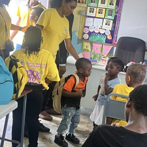Happy students interacting with each other after receiving their backpack and package from the Love of Hearts Foundation
