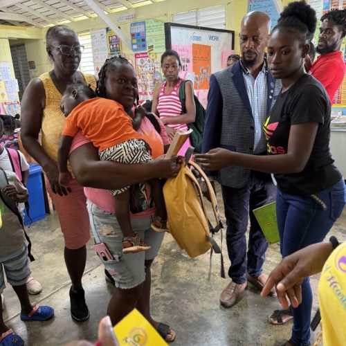 Happy Mom and student receiving their package from the Love of Hearts Foundation